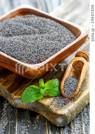 Poppy seeds in a wooden bowl and scoop. Poppy seeds in a wooden bowl and scoop. 28685886