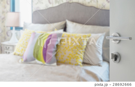 opened door to blurred colorful pillows on bed 28692666