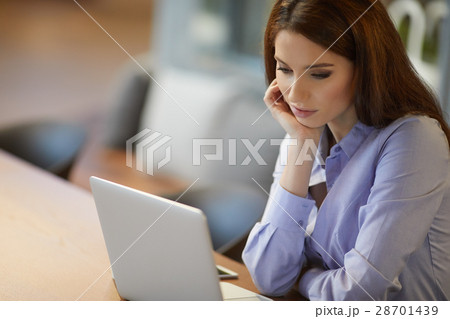 Portrait of successful businesswoman working with laptop in offi Portrait of successful businesswoman working with laptop in offi 28701439