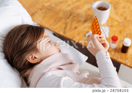 Little ill girl taking pills 28708103