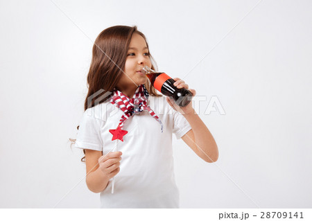 Delighted little girl drinking in the studio 28709141