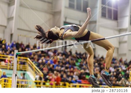 Young girl jumping over bar in high jump contest. Young girl jumping over bar in high jump contest. 28710116