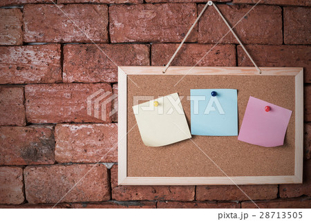paper note on wood board and old brick background 28713505