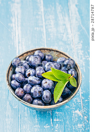 Bowl of blueberry with leaves on table Bowl of blueberry with leaves on table 28714787