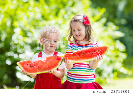 Kids eating watermelon in the garden Kids eating watermelon in the garden 28715301