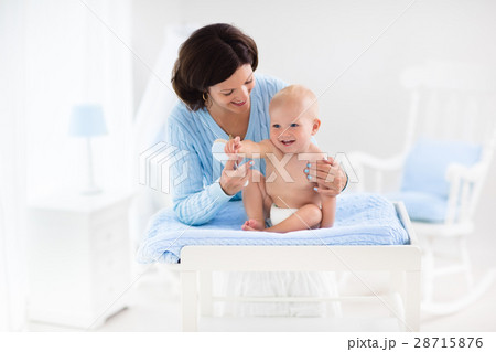 Mother changing diaper to baby boy 28715876
