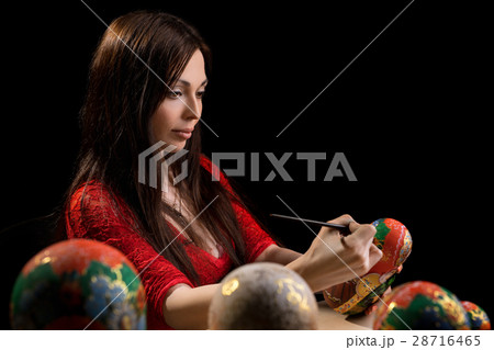 Pretty woman drawing patterns on matrioshka Pretty woman drawing patterns on matrioshka 28716465