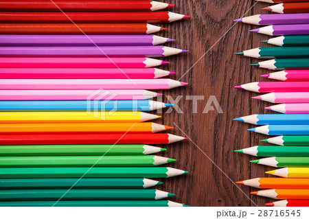 colored pencils on brown wooden background lying 28716545