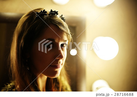 Beautiful glamorous woman in fur coat posing near mirror with bulb 28716688