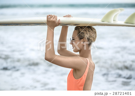 Girl with surfboard on beach Girl with surfboard on beach 28721401