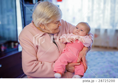 Great grandmother holding newborn baby grandchild Great grandmother holding newborn baby grandchild 28725200