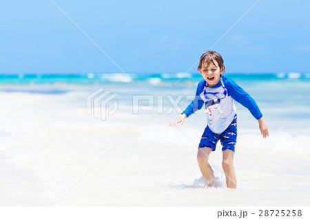 little blond kid boy having fun on tropical beach 28725258