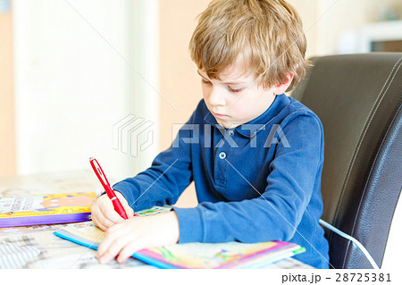 preschool kid boy at home making homework writing 28725381