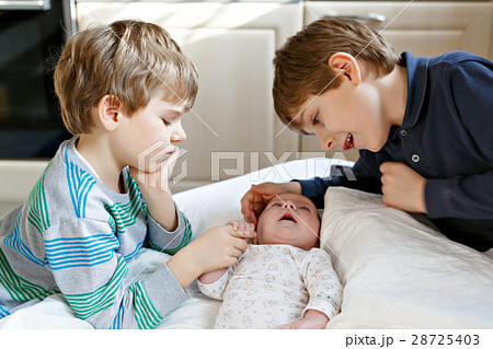 Two little kids boys playing with newborn baby 28725403