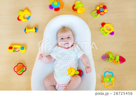 Cute baby girl playing with colorful rattle toys Cute baby girl playing with colorful rattle toys 28725456