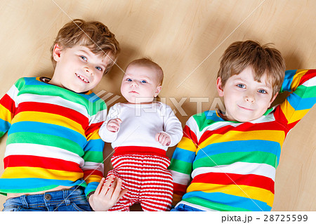 Two happy little preschool kids boys with newborn 28725599