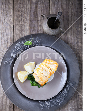 Fried cod fillets and spinach 28726127