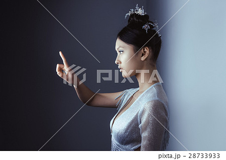 Young pretty asian futuristic woman pressing an Young pretty asian futuristic woman pressing an 28733933