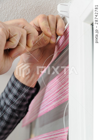 Installing fabric roller blinds. 28742781