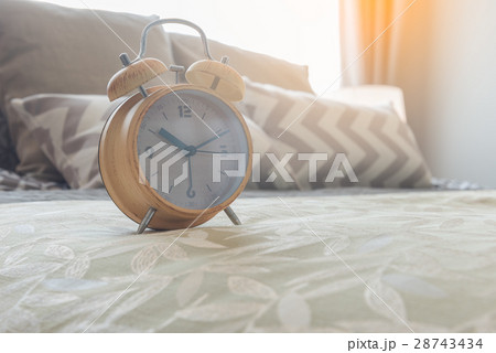 modern alarm clock on bed in bedroom 28743434