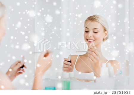 woman with lipstick applying make up at bathroom 28751952