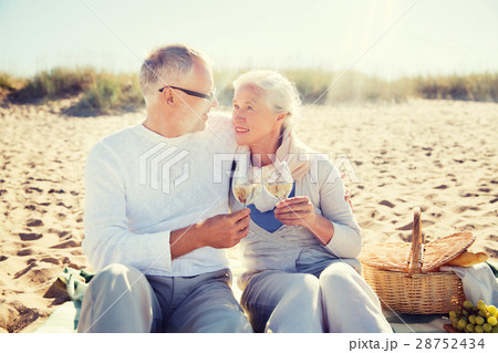 happy senior couple talking on summer beach 28752434