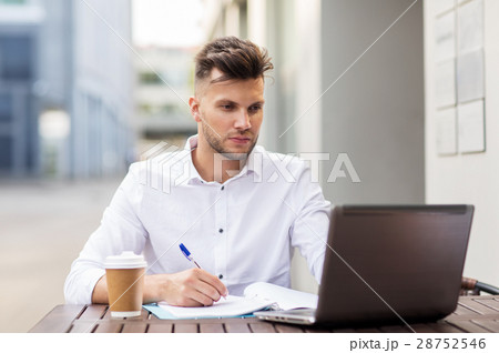man with laptop and coffee at city cafe 28752546