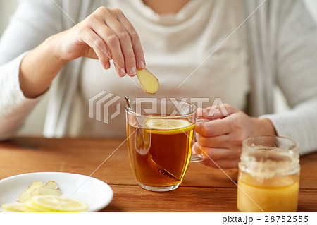 close up of ill woman drinking tea with ginger 28752555