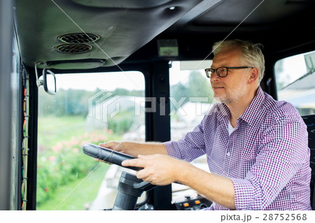 senior man driving tractor at farm senior man driving tractor at farm 28752568