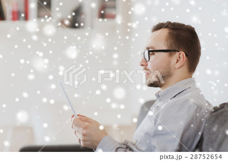 man with tablet pc at home over snow 28752654