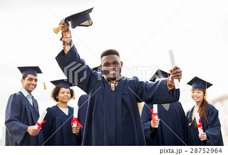 happy students in mortar boards with diplomas 28752964