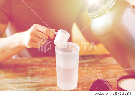 close up of man with protein shake bottle and jar 28753233