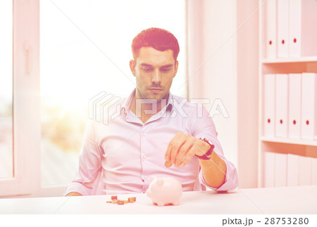businessman with piggy bank and coins at office businessman with piggy bank and coins at office 28753280