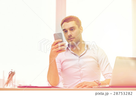 businessman with smartphone and laptop at office 28753282