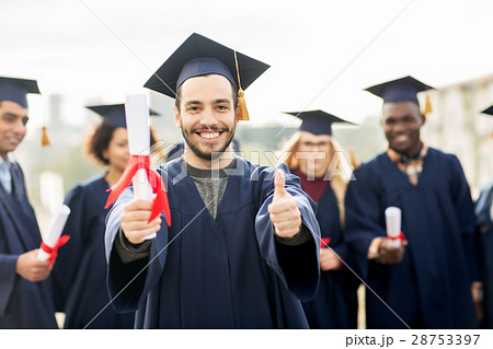 happy students with diplomas showing thumbs up 28753397