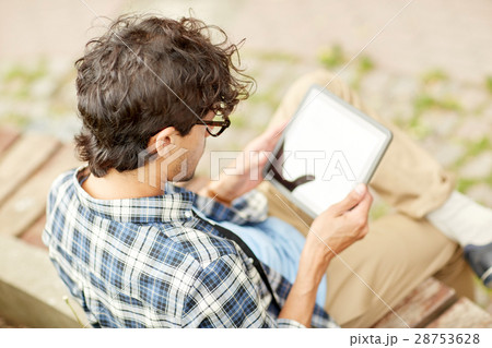 man with tablet pc sitting on city street bench 28753628