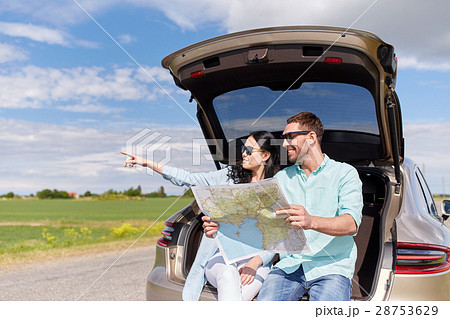 happy man and woman with road map at hatchback car 28753629