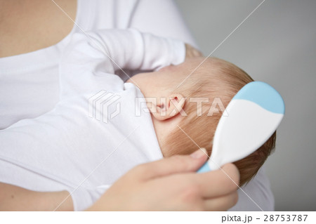 close up of mother brushing newborn baby hair close up of mother brushing newborn baby hair 28753787