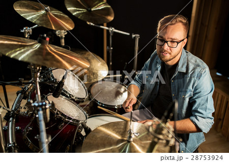 male musician playing drums and cymbals at concert 28753924