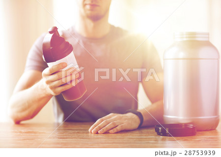 close up of man with protein shake bottle and jar close up of man with protein shake bottle and jar 28753939