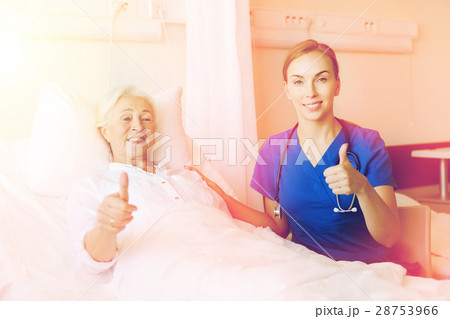 nurse and senior woman showing thumbs up at clinic nurse and senior woman showing thumbs up at clinic 28753966