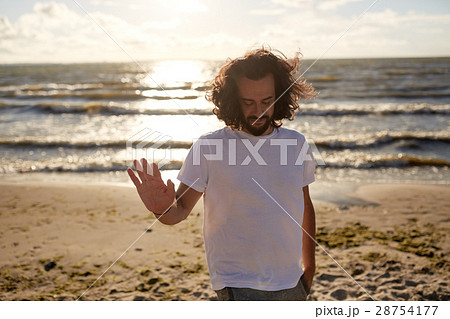 happy man in white t-shirt on beach over sea 28754177
