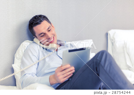 businessman with tablet pc and phone in hotel room 28754244