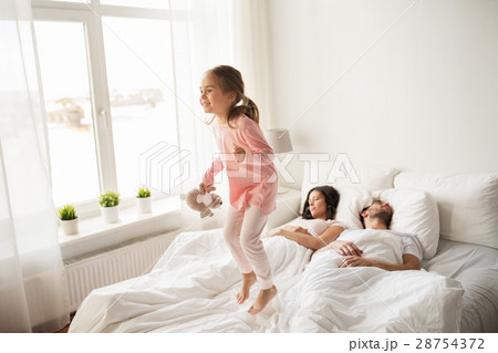 happy child with toy and parents in bed at home 28754372