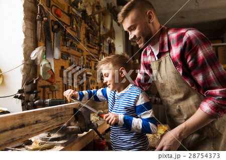father and son with rasp working at workshop 28754373