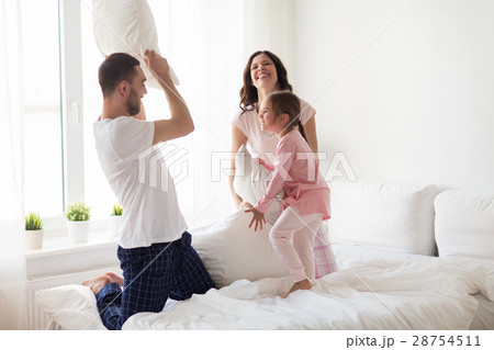happy family waking up in bed at home 28754511