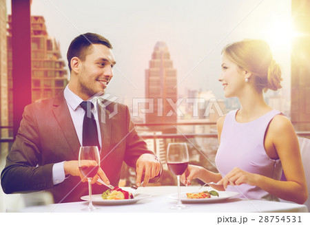 smiling couple eating main course at restaurant 28754531