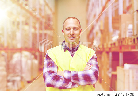 happy man in reflective safety vest at warehouse 28754709