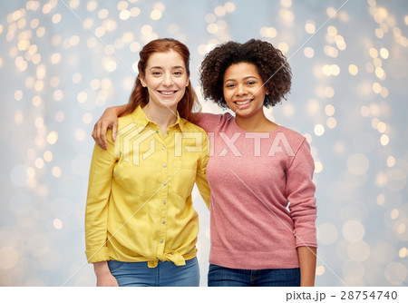 happy smiling women hugging over holidays lights happy smiling women hugging over holidays lights 28754740
