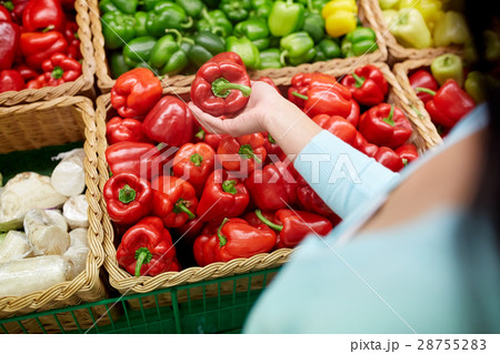 woman with basket buying peppers at grocery store 28755283